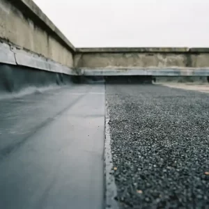Plat dak met EPDM-membraan naast bitumen dakbaan, scherpe naadaansluiting zichtbaar onder bewolkte Nederlandse lucht.