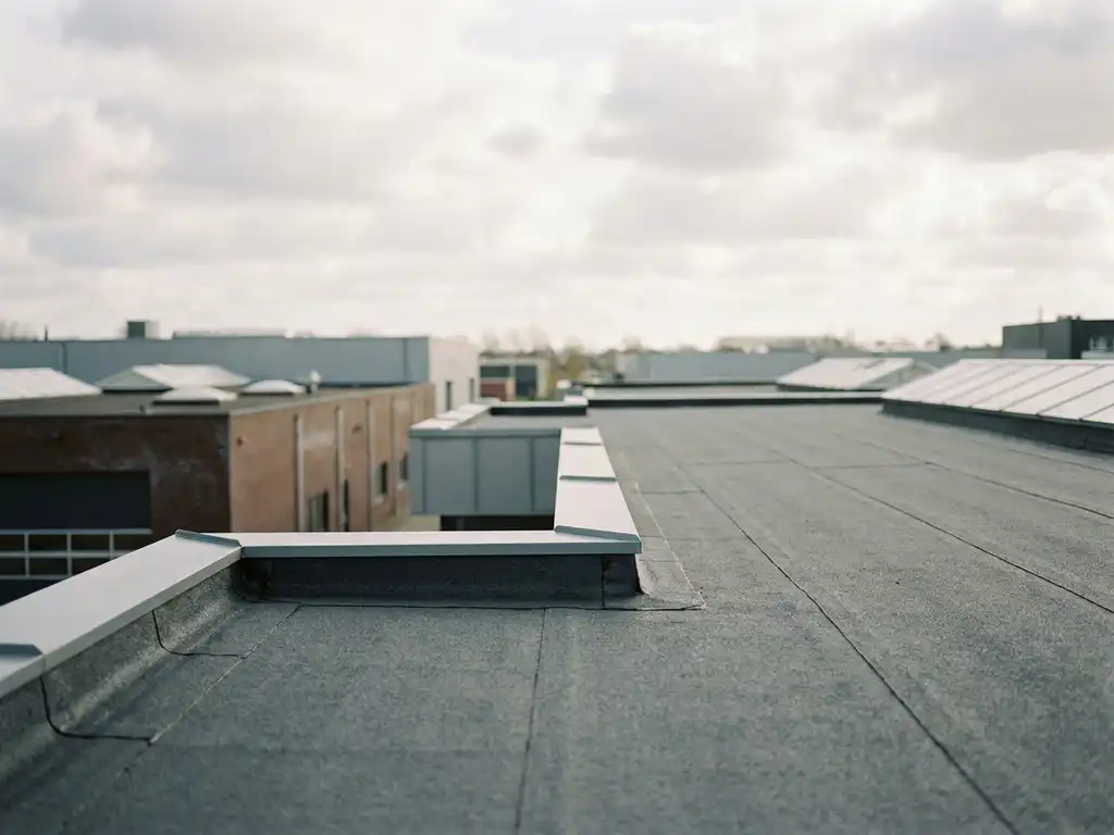 Nieuw aangelegd EPDM-dakmembraan op commercieel plat dak met strakke naden en randafwerking onder bewolkte Nederlandse lucht.