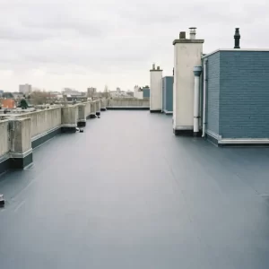 Gerenoveerd plat dak met donkergrijze EPDM-membraan op Nederlands appartementencomplex, nette afwerkingsranden en afvoerpunten zichtbaar.